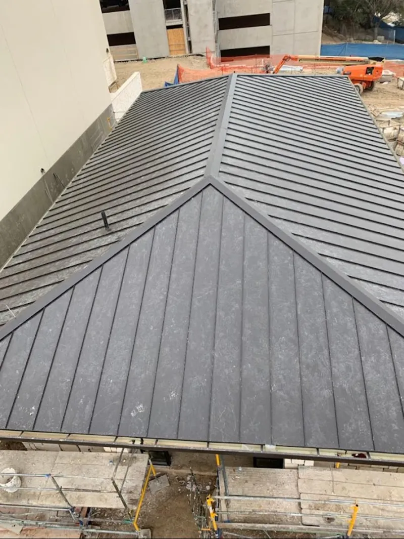 Commercial metal roof construction with crane equipment in Middletown